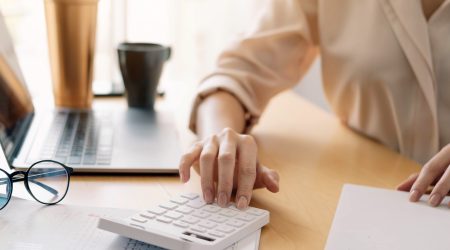 Close up view of bookkeeper or financial inspector hands making report, calculating or checking